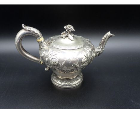 A William IV silver Teapot of ogee form, finely embossed floral branches, flower finial engraved crest, leafage scroll handle