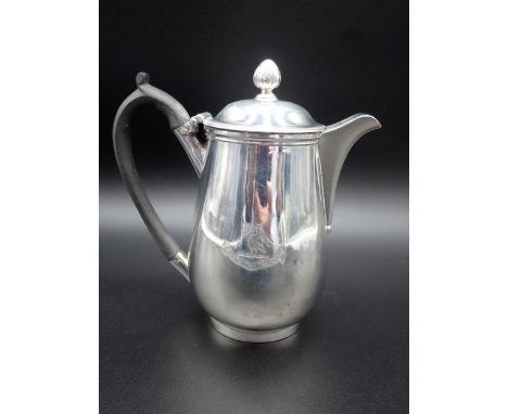 A George III silver baluster Hot Water Jug, engraved crest, the hinged cover with bud finial, ebonised scroll handle, London 