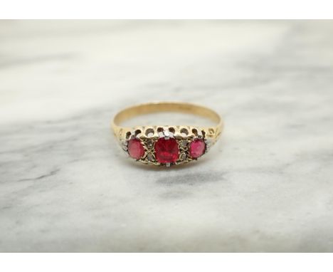 A Ruby and Diamond Ring set three graduated oval-cut rubies interspersed with pairs of rose-cut diamonds, stamped 18ct, ring 