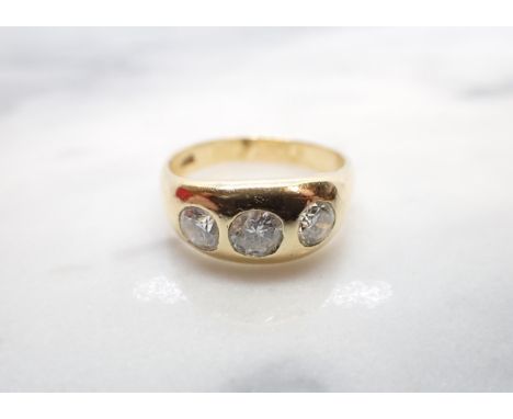 A Diamond three stone Ring gypsy-set graduated brilliant-cut stones (centre stone chipped), stamped 18K, ring size T, approx 