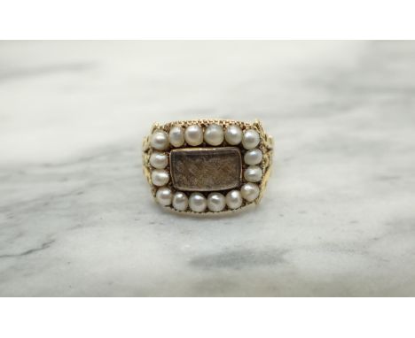 A Georgian Mourning Ring having rectangular panel of plaited hair within frame of split pearls, ring size P, approx 4.10gms 