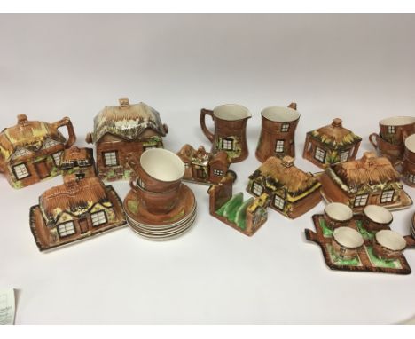 A collection of cottage ware ceramics including biscuit barrels tea pots butter dishes cups saucers and condiments. (a lot) N