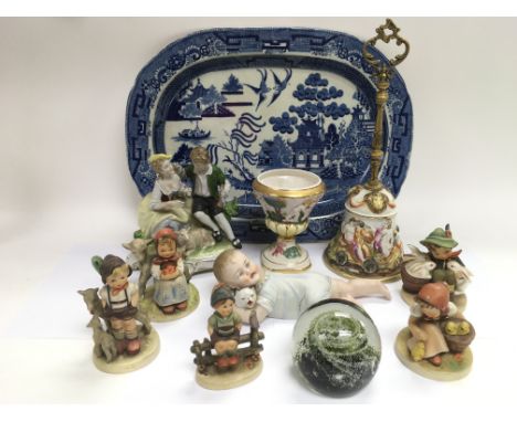 A collection of ceramics including Hummel figures, a Caithness paperweight, bisque baby, Victorian blue and white meatplate, 