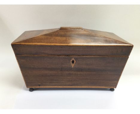 An inlaid mahogany tea caddy of sarcophagus form, approx 29.5cm x 17.5cm x 16.5cm. Shipping category B.