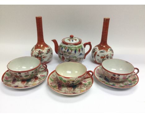 A small collection of Oriental ceramics comprising a pair of bud vases, teapot and three cups and saucers.