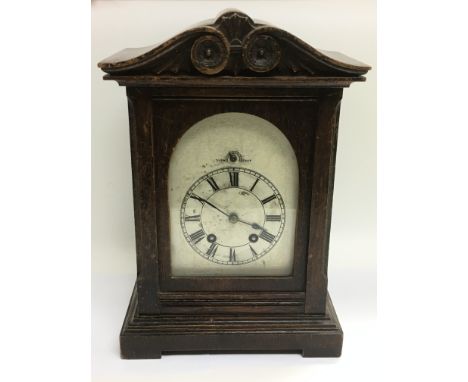 An oak mantle clock with a silvered dial, approx height 35cm. Comes with key and pendulum. NO RESERVE