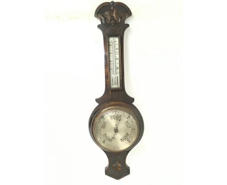 Vintage oak barometer with carved designs, approximately 68cm long.