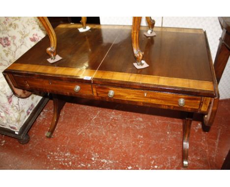 A Regency mahogany sofa table, circa 1815, the rectangular top with rounded corners to the fall-flaps above two frieze drawer