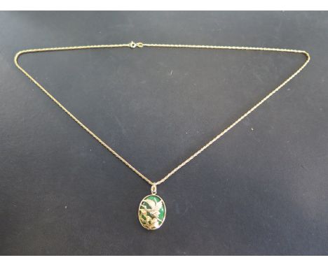 An 18ct yellow gold necklace with a Jade and gold pendant - the pendant decorated with bird amongst foliage - in good conditi