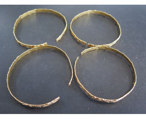 Four presumed 22ct yellow gold bangles with engraved decoration - approx weight 40.3 grams - each bangle has been cut to fit 