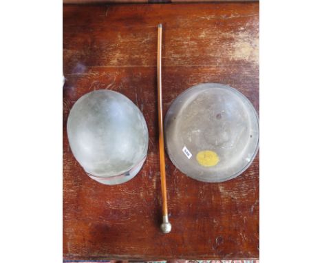 A tin helmet, an American helmet and a swagger stick 