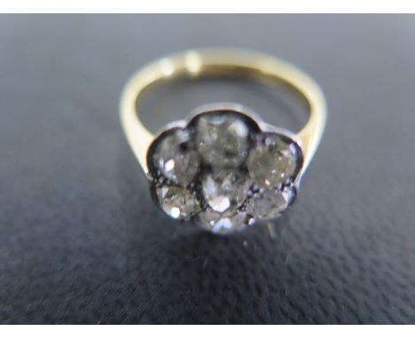 An 18ct yellow gold and platinum seven stone diamond cluster ring size L - approx weight 2.9 grams - one diamond with small s