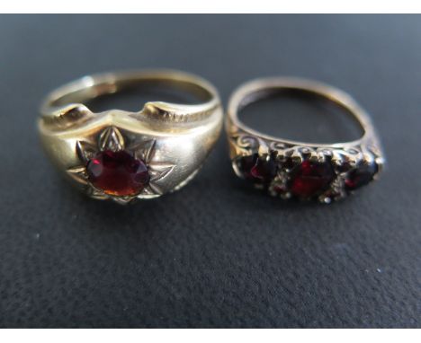 A 9ct yellow gold and garnet ring size Q/R - approx weight 3.8 grams and a 9ct yellow gold three stone garnet ring size L - a