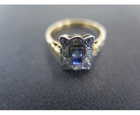 An 18ct yellow gold and platinum diamond and sapphire ring size L - the two central square cut sapphires surrounded by ten di