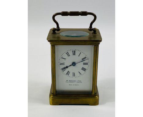 An early 20th century brass cased carriage clock timepiece with a French movement and bevelled glass, with an enamelled dial 