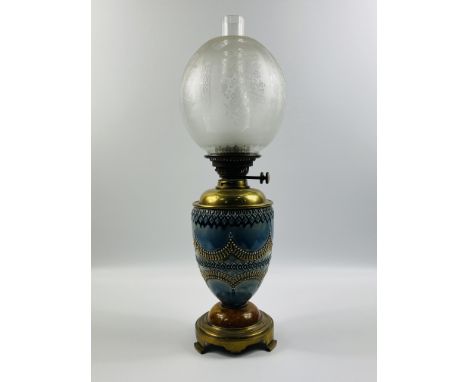 A late 19th century Doulton Lambeth style oil lamp with a glass chimney and etched glass globular shade decorated in typical 