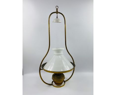 A brass hanging oil lamp with a milk glass shade.88cms high x 38.5cms diameter.Estimate £20-30.