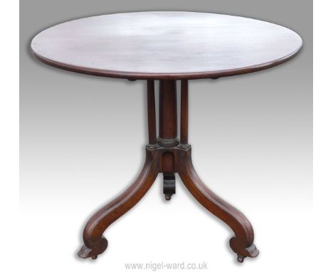 A remarkably heavy Mahogany circular Snap Top Table having a most uncommon design cylindrical pillar support with three subsi