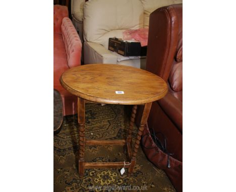 An oval light Oak occasional Table standing on twist legs united by a perimeter stretcher, 23'' x 15 1/2'' x 29'' high.