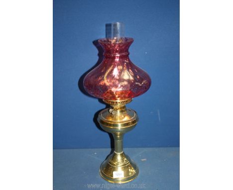 A Brass finished Oil Lamp with ornate pink glass shade and clear glass chimney, 22'' tall.