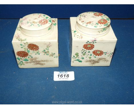 A pair of Ivory shaded square shaped caddies with one interior lid missing under the covers and both with top finial knobs mi