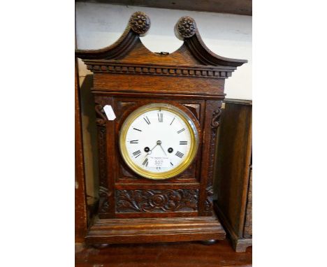 Victorian carved oak mantle clock with swan neck pediment having French movement, striking on a gong, 15" high