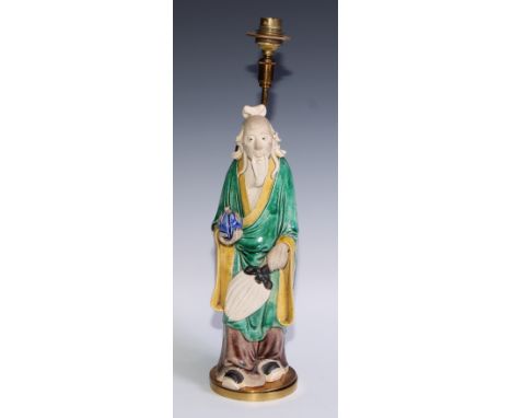 A Chinese sancai figure, of an immortal holding a peach, 32.5cm high, mounted as a lamp, 40cm to base of fitting 