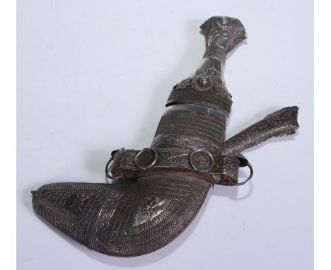 A Middle Eastern jambiya dagger, 12cm curved blade with central ridge, the handle and scabbard chased with flowers and aplied