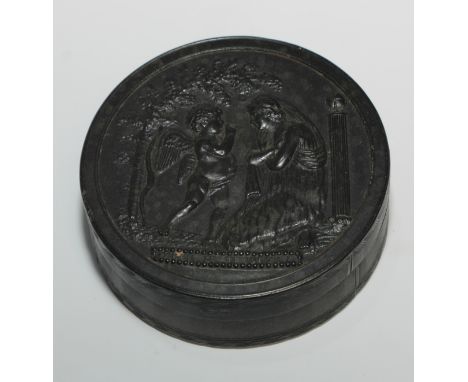 A 19th century pressed horn circular snuff box, the cover with an allusion to Cupid and Psyche, titled Parle Je Tecoute, engi