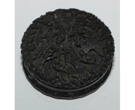 A 19th century Chinese tortoiseshell circular snuff box and cover, profusely carved in relief with traditional figures and st