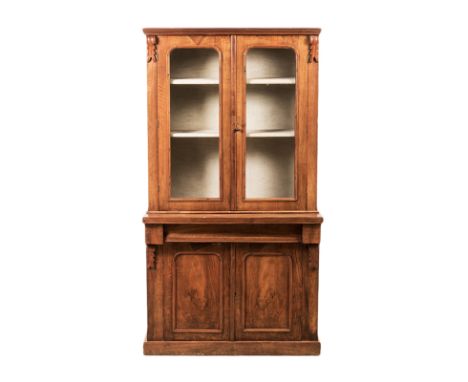 A VICTORIAN MAHOGANY BOOKCASE in two parts, the outswept moulded cornice above a pair of glazed doors flanked by corbels and 