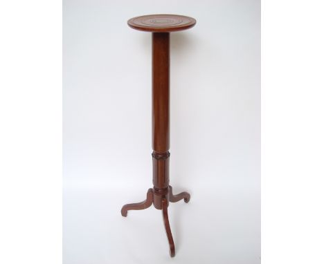A William IV mahogany torchere, the circular platform top on tapering turned stem with carved leaf band on tripod base.
122cm