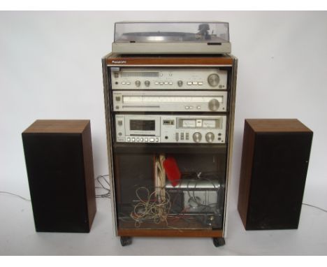 A Panasonic SL - H304 Automatic turntable, with amplifier, stereo tuner, cassette deck and speakers, in a cabinet. 