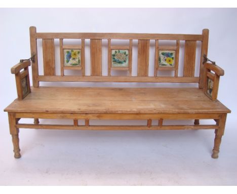 An early 20th Century Anglo Indian swing back teak bench, the back and arms inset with reverse glass painted floral panels.  