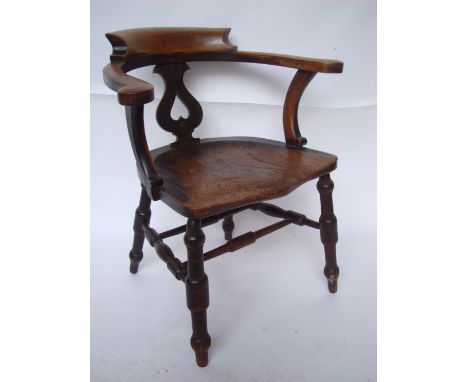 A late 19th Century ash, elm and beech smokers bow or captains chair, with heart pierced splat, on raised turned legs united 