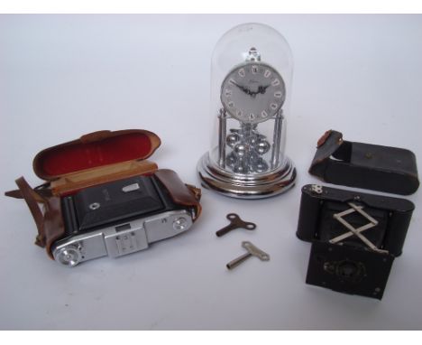 A German Kern anniversary clcok under dome, a Zeiss Ikon Prontor-S  camera and an Eastman Kodak Co vest pocket folding camera