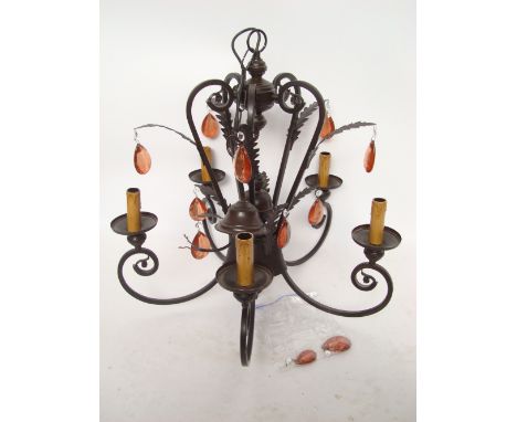 A modern six light wrought iron chandelier with scroll branches and hung with pear shaped coloured cut glass drops. 