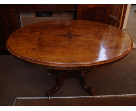 A Victorian oval walnut breakfast table, the quarter veneered tilt action top marquetry inlaid and strung with moulded edge, 