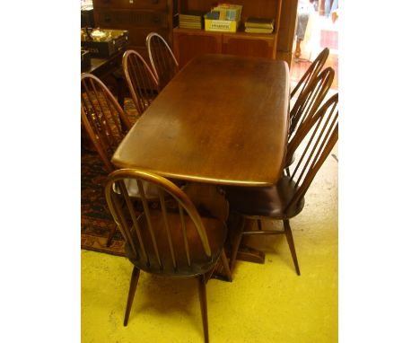 A set of seven Ercol hoop stick back chairs with elm seats and an Ercol  refectory table. 