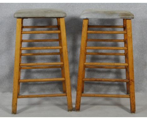 A pair of vintage teak framed vaulting horses or exercise stools with tops upholstered in suede. H.89cm 