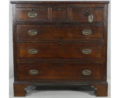A Georgian country oak and mahogany crossbanded chest of drawers with ebony stringing on shaped bracket feet. H.105 W.104 D.5