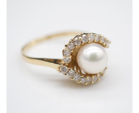 A Vintage 14 carat yellow gold, cultured pearl and diamond cocktail ring. Set to centre with a white cultured pearl with a di