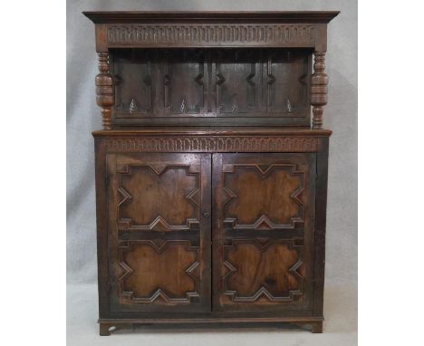 An 18th century country oak court cupboard with stepped moulded cornice and panelled superstructure raised on turned baluster