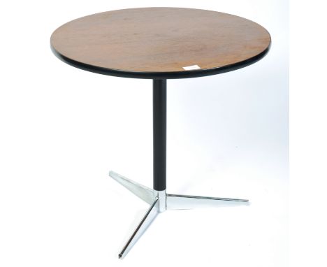 A late 20th century retro vintage side / end table having a teak wood round top with black trim raised on polished aluminium 