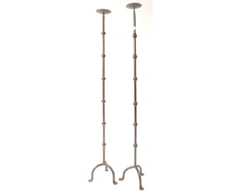 A pair of 20th century retro vintage ecclesiastical steel candle stick holders of tall form comprising of tripod bases with u