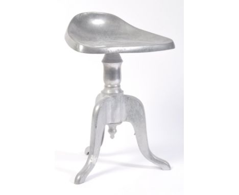 A 20th century retro vintage cast alloy metal pedestal stool comprising of a tractor type seat raised on a french inspired pe