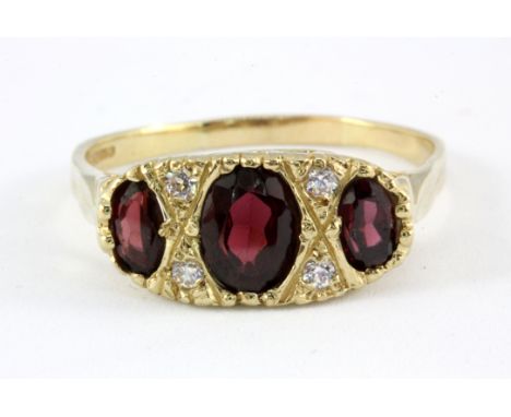 A 9ct yellow gold garnet and white stone set ring, (T.5).