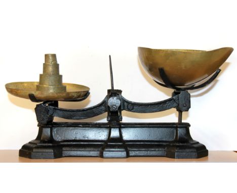 A cast iron and brass scale and weights.