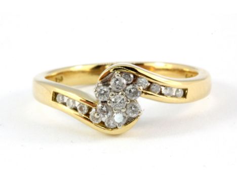 An 18ct yellow gold diamond set cluster ring with diamond set shoulders, (P).