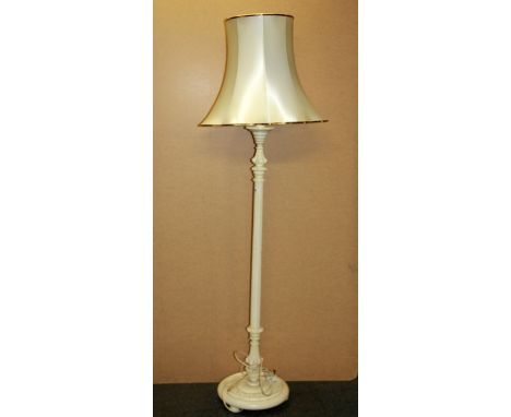 A cream painted wooden standard lamp and shade.
